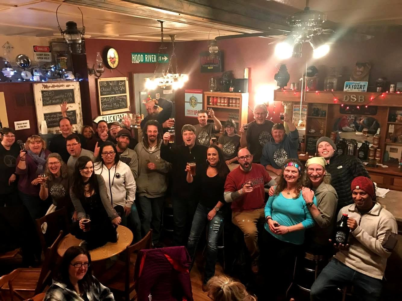 A packed Dakota Shivers taproom raising glasses together